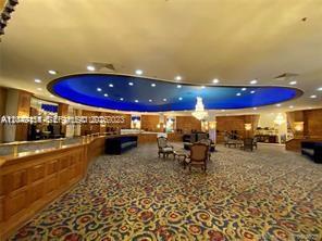 A large, carpeted lobby features a blue recessed ceiling, wood paneling, and several armchairs — 5445 Collins Ave # 721, Miami Beach FL 33140, MIAMI BEACH, FL