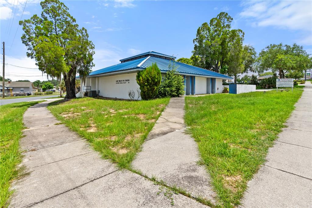 A single-story commercial building with a blue metal roof sits on a grassy lot — 441 S 11TH STREET, LAKE WALES, FL