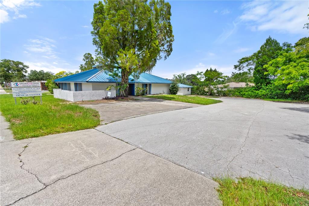 A single-story commercial building with a blue metal roof and a large parking lot — 441 S 11TH STREET, LAKE WALES, FL