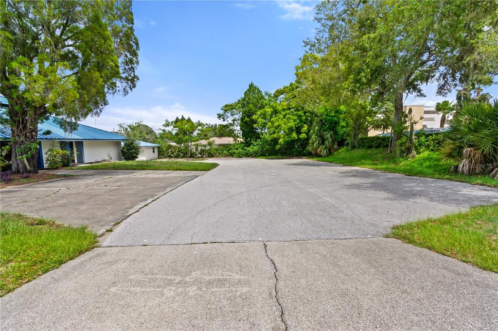 A paved parking area sits in front of a building with a blue metal roof — 441 S 11TH STREET, LAKE WALES, FL