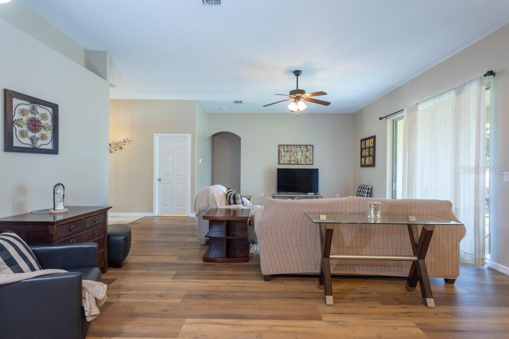 A living room features wood-look flooring, a ceiling fan, and a beige sofa — 35 FOXHALL LANE, PALM COAST, FL