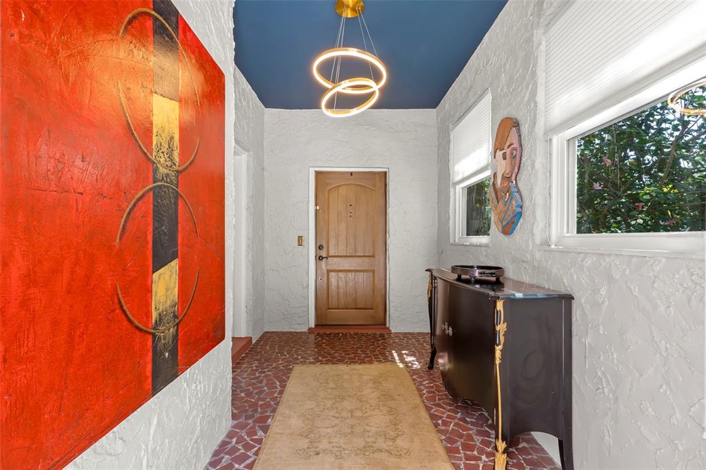 An entryway features a textured white wall, a blue ceiling, a wooden door, and tile — 1125 11TH AVENUE N, ST PETERSBURG, FL