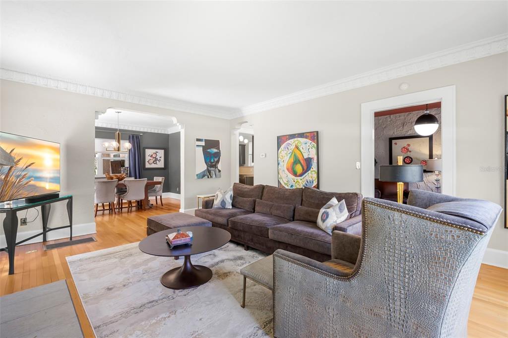 A living room features a brown sectional sofa, a patterned armchair, and a dining area — 1125 11TH AVENUE N, ST PETERSBURG, FL
