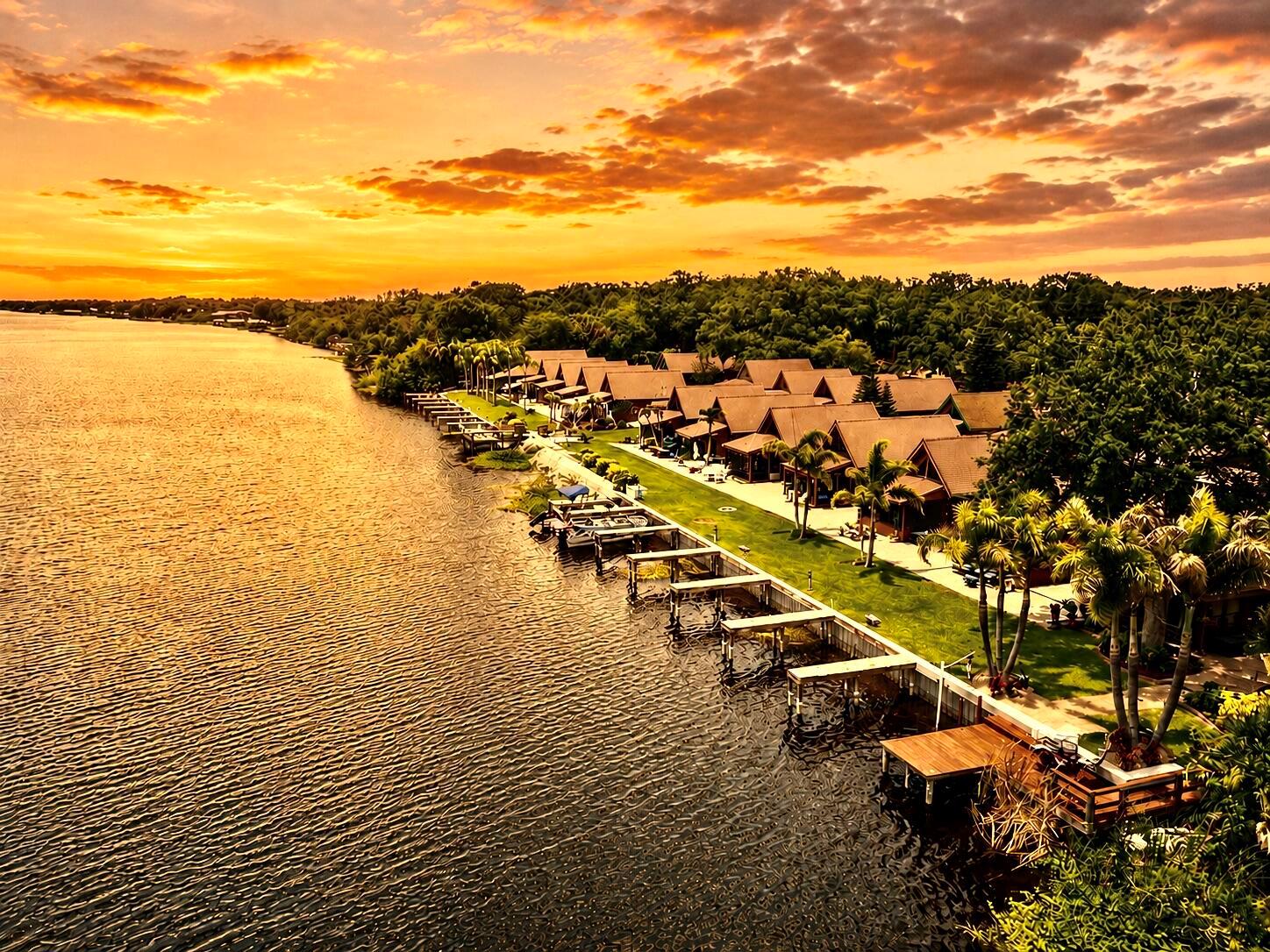 An aerial view of waterfront cabins with private docks along a lake at sunset — 8346 Us-441 # 10, Okeechobee FL 34974, OKEECHOBEE, FL