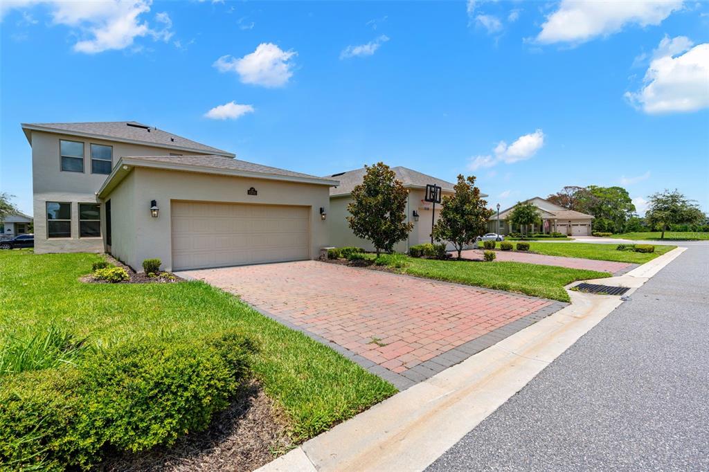 A two-story house with a tan stucco exterior and a brick paver driveway — 15741 FOUNTAIN SPRINGS ROAD, WINTER GARDEN, FL