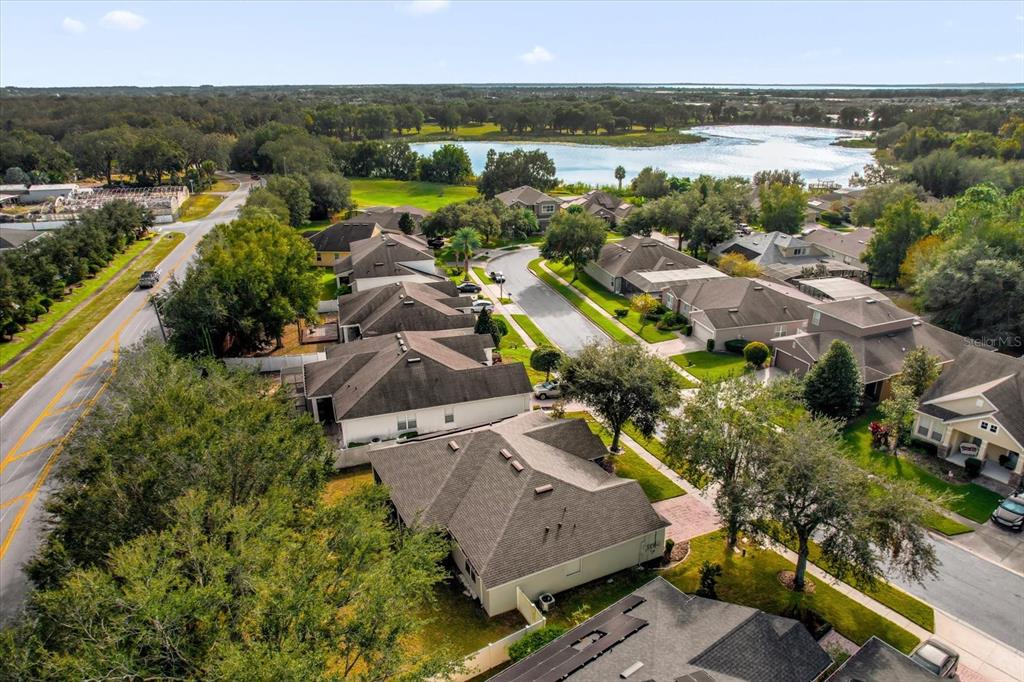 An aerial view shows a suburban neighborhood with houses, a road, and a nearby lake — 2284 PICKFORD CIRCLE, APOPKA, FL