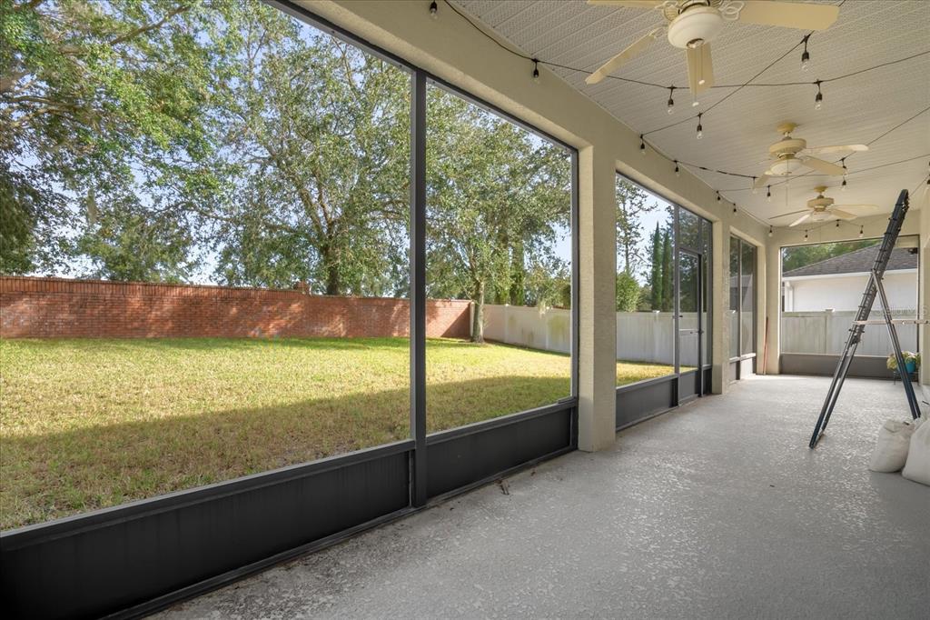 A screened-in patio with a concrete floor, ceiling fans, and a view of the backyard — 2284 PICKFORD CIRCLE, APOPKA, FL