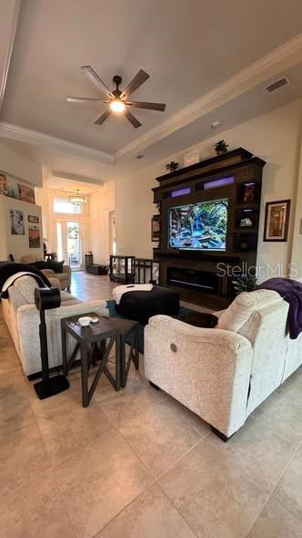 A living room features a large entertainment center, a ceiling fan, and light-colored tile flooring — 20 SPRING STREET, PALM COAST, FL