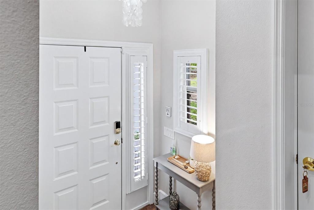A white front door with a side window and a console table in a foyer — 5290 DESCANSO COURT UNIT 201B19, SARASOTA, FL