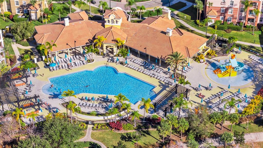 An aerial view of a community swimming pool area with a splash pad and clubhouse — 4114 BREAKVIEW DR DRIVE UNIT 10602, ORLANDO, FL