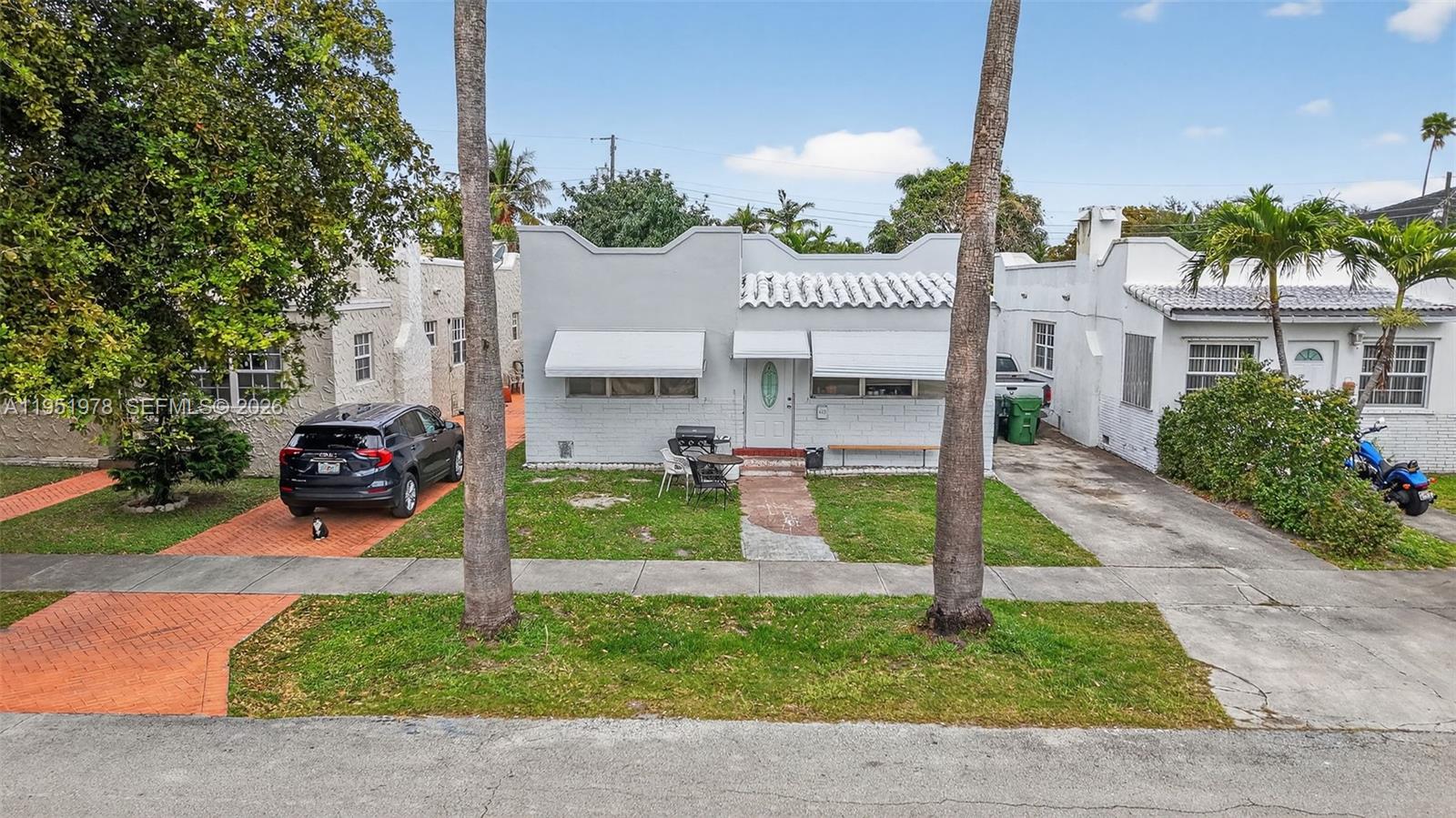 A light gray single-story house with a white roof and two palm trees in front — 623 NE 4th St, Hallandale Beach FL 33009, HALLANDALE BEACH, FL