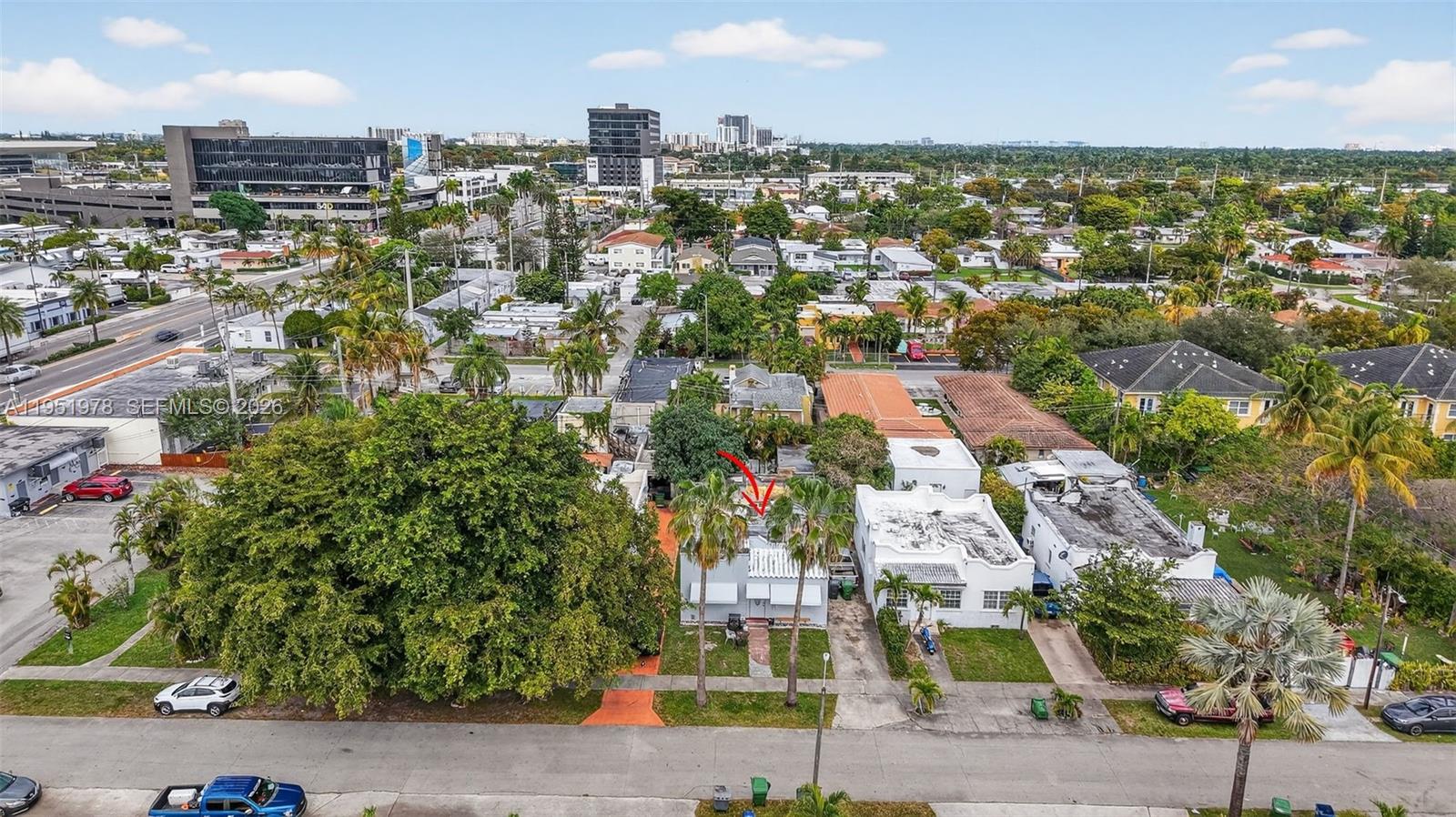 An aerial view shows a residential street with a small house marked by a red arrow — 623 NE 4th St, Hallandale Beach FL 33009, HALLANDALE BEACH, FL