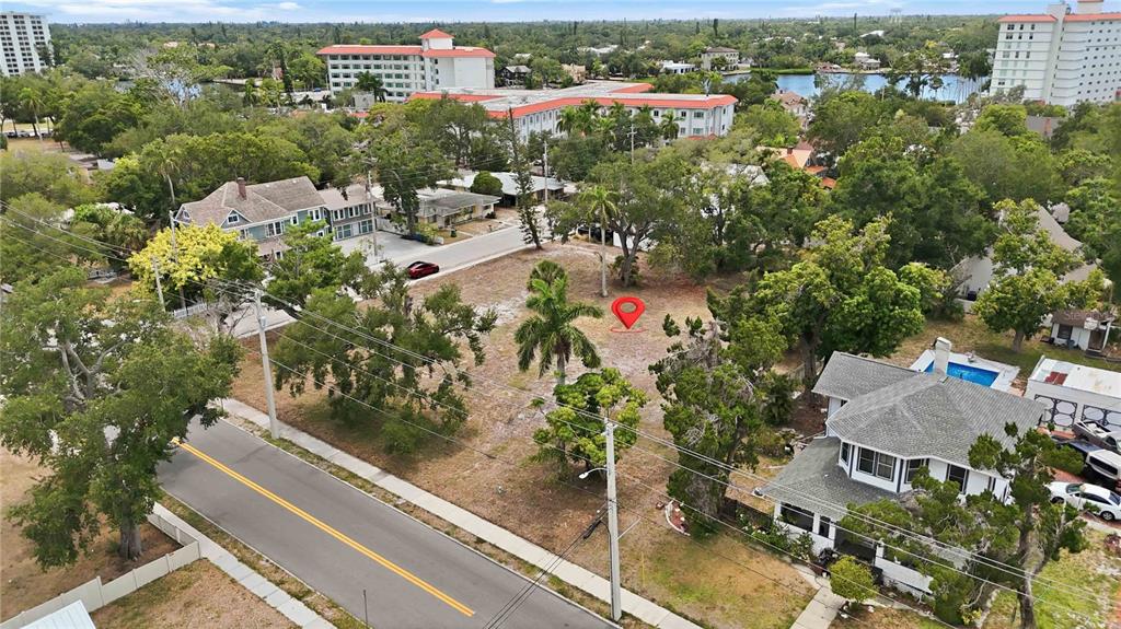 An aerial view shows a vacant, tree-lined lot situated between two houses near a road — 204 15TH STREET W, BRADENTON, FL