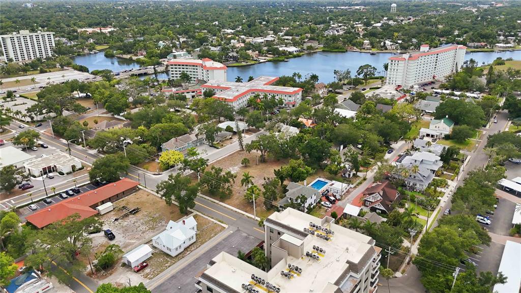 An aerial view shows a residential neighborhood with buildings, a body of water, and trees — 204 15TH STREET W, BRADENTON, FL