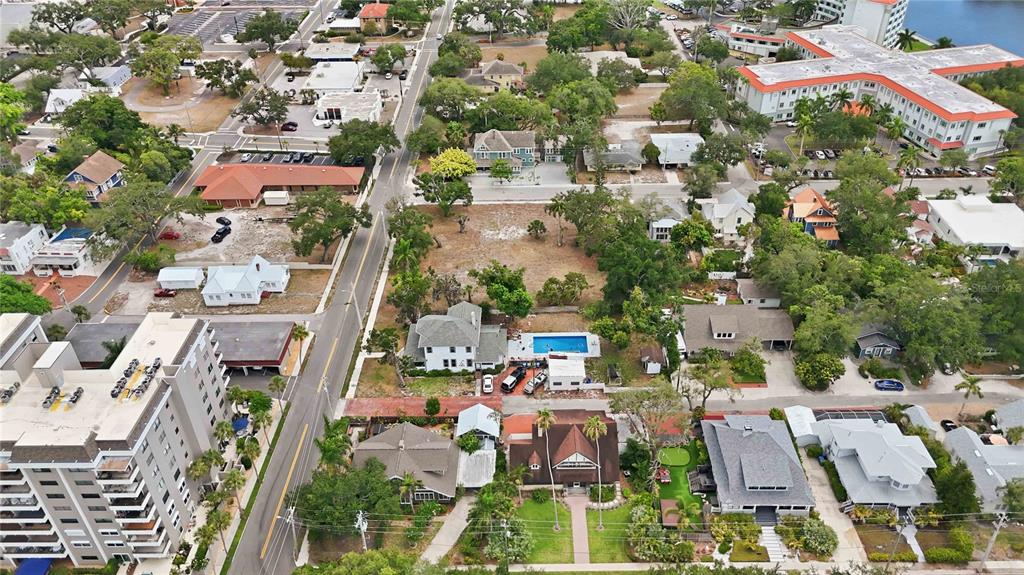 An aerial view shows a residential neighborhood with houses, a swimming pool, and a large building — 204 15TH STREET W, BRADENTON, FL