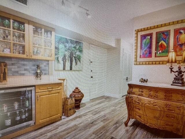 A room features a built-in wine cooler, wooden cabinetry, and a decorative chest of drawers — 300 N Highway A1a # 204a, Jupiter FL 33477, JUPITER, FL