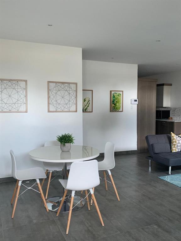 A dining area with a round table and four chairs sits in an open-concept room — Atlantic View ISLA VERDE, CAROLINA, PR