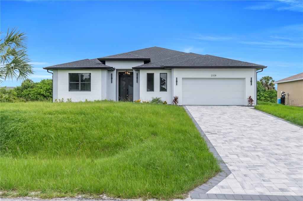 A single-story house with a white exterior, dark roof, and a paved driveway — 2328 IRONDALE RD, NORTH PORT, FL