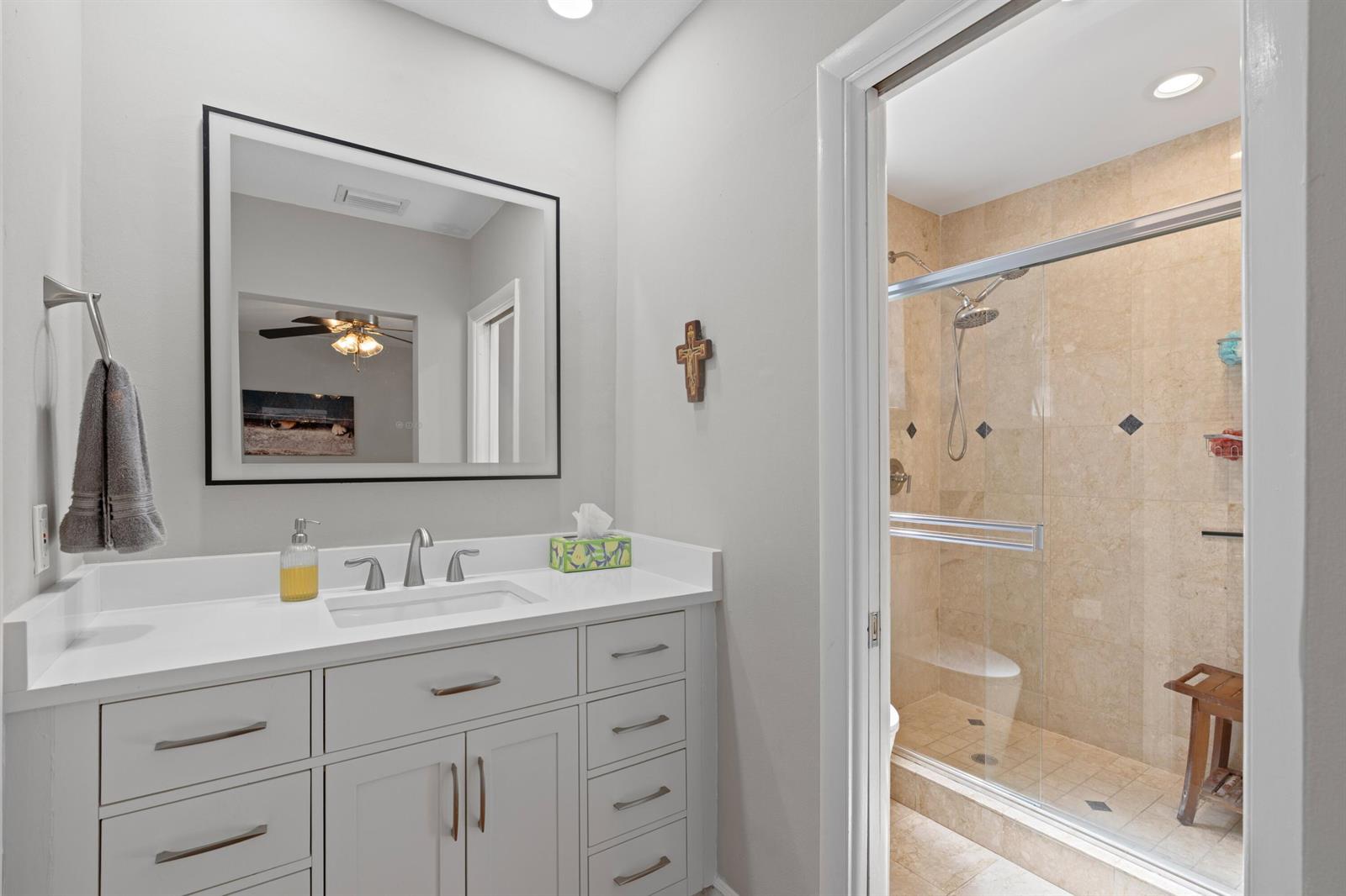 A bathroom features a white vanity with a mirror and a glass-enclosed tiled shower — 200 SW 5th Street, Boca Raton FL 33432, BOCA RATON, FL