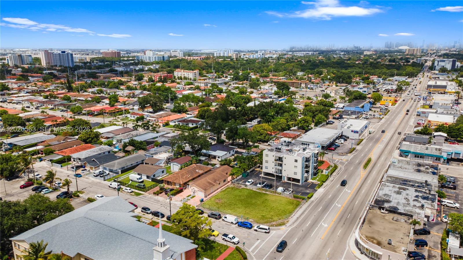 An aerial view shows a suburban neighborhood with houses, a commercial building, and a road — 5895 W Flagler St, Miami FL 33144, MIAMI, FL