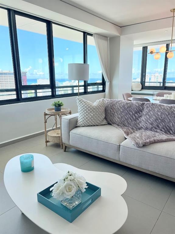 A living room features a light-colored sofa, a kidney-shaped coffee table, and floor-to-ceiling windows — 1511 22 PONCE DE LEON AVE. UNIT 9151, SAN JUAN, PR