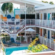 A multi-story motel features a central swimming pool, lounge chairs, and white metal balcony railings — 7310 Harding Ave # 1, Miami Beach FL 33141, MIAMI BEACH, FL