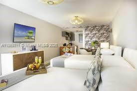 A hotel-style room features two beds, a television, and a small kitchenette area — 7310 Harding Ave # 1, Miami Beach FL 33141, MIAMI BEACH, FL