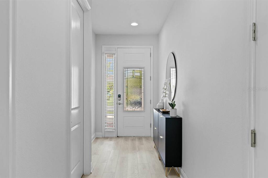 A bright entryway features a white door with a stained glass insert and light flooring — 451 BURMA STREET, KISSIMMEE, FL