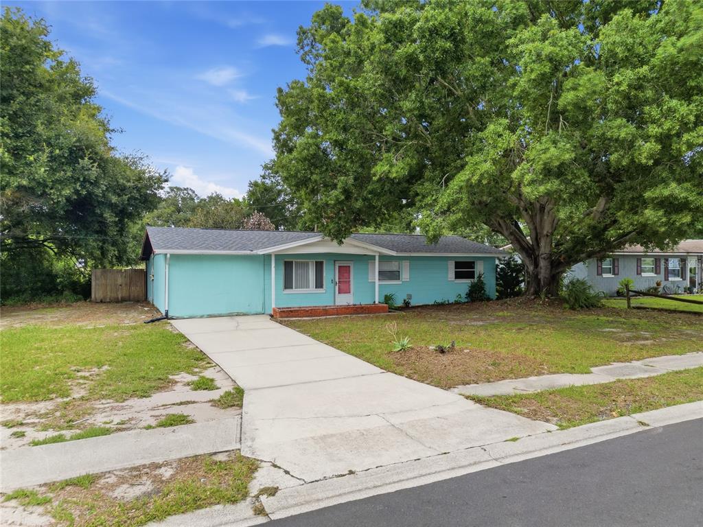 A single-story teal house with a concrete driveway and a large tree in the yard — 120 E HOFFMAN ST, LAKE ALFRED, FL