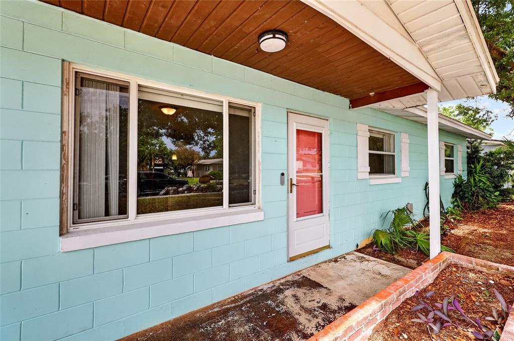 A light blue concrete block house exterior features a front porch, window, and red door — 120 E HOFFMAN ST, LAKE ALFRED, FL
