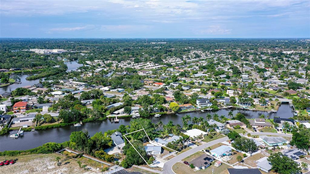 An aerial view shows a residential property outlined in white along a canal — 2103 LUSITANIA DRIVE, SARASOTA, FL