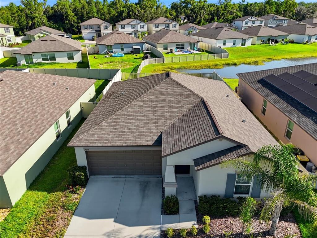 An aerial view shows a single-story suburban house with a brown shingled roof — 4316 TROTTERS WAY, LAKELAND, FL