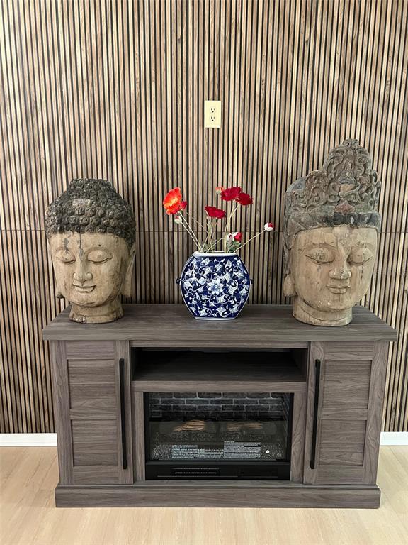 A media console with an electric fireplace sits against a wall with wood slat paneling — 5970 80TH STREET N UNIT 101, ST PETERSBURG, FL