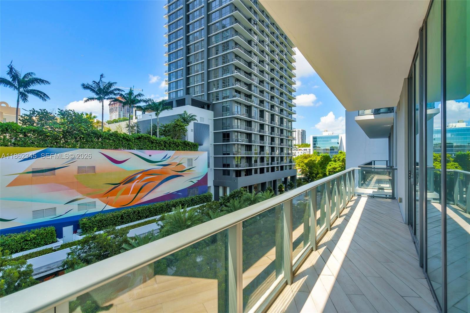 A modern living room features a white sofa, blue chaise, and floor-to-ceiling windows — 501 NE 31st St # 306, Miami FL 33137, MIAMI, FL