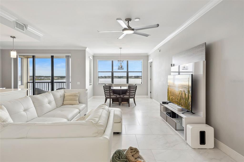 A living room with white tile floors, a white sectional sofa, and a dining area — 16300 COUNTY ROAD 455 UNIT 302, MONTVERDE, FL