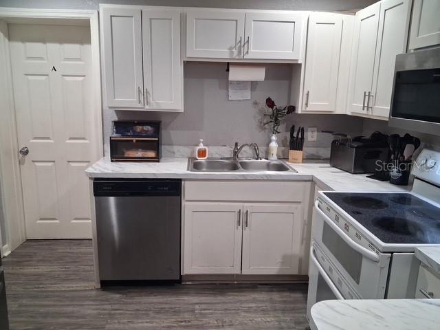 A kitchen features white cabinets, stainless steel appliances, and a marble-patterned countertop — 505 HOLT CIRCLE, WINTER HAVEN, FL