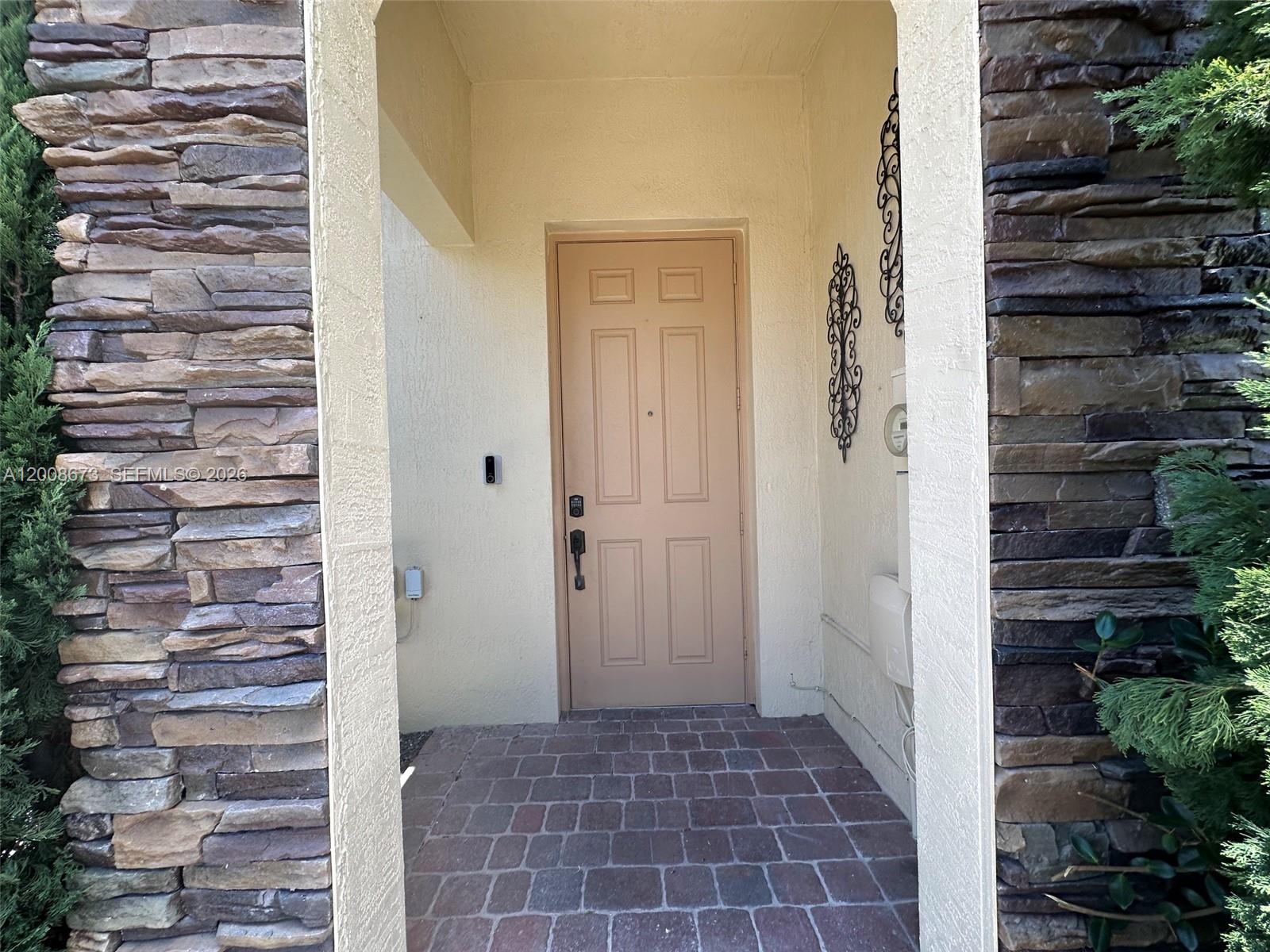 A front entryway features a tan door, stone siding, and a brick-paved porch — 3211 SE 6th St, Homestead FL 33033, HOMESTEAD, FL