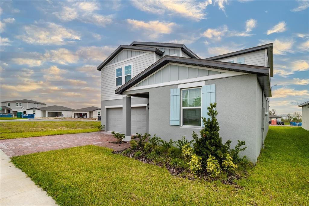 A two-story gray house with a brick driveway and light blue shutters — 3033 CASSIDY LANE, HAINES CITY, FL