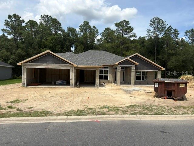 A newly constructed single-story house with a two-car garage and a dumpster in the yard — 17889 SW 61ST LANE ROAD, DUNNELLON, FL
