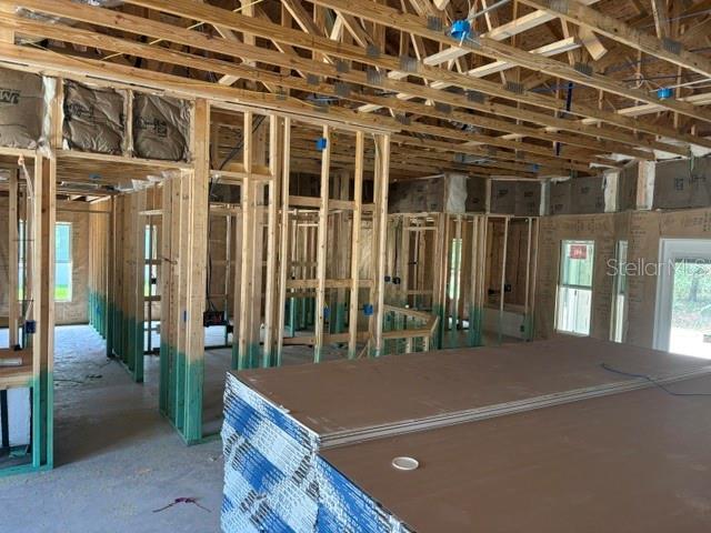 An interior view of a house under construction showing exposed wood framing and drywall stacks — 17889 SW 61ST LANE ROAD, DUNNELLON, FL