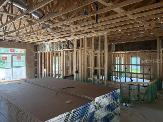 An interior view of a house under construction showing exposed wood framing and drywall stacks — 17889 SW 61ST LANE ROAD, DUNNELLON, FL