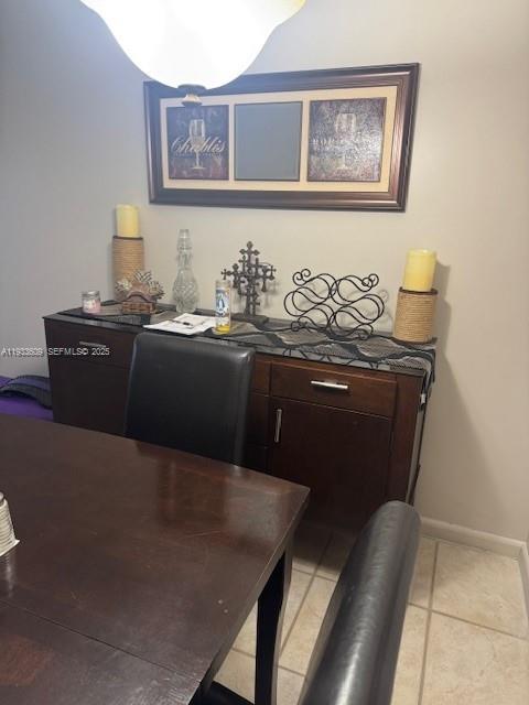 A dining room features a dark wood sideboard topped with decorative items and wall art — 4299 NW 16th St # 103, Lauderhill FL 33313, LAUDERHILL, FL