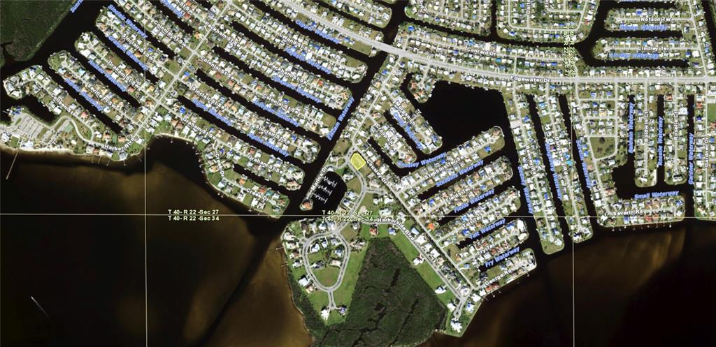 This aerial map shows a residential neighborhood with canal-front homes and a highlighted vacant lot — 4400 GRASSY POINT BOULEVARD, PORT CHARLOTTE, FL