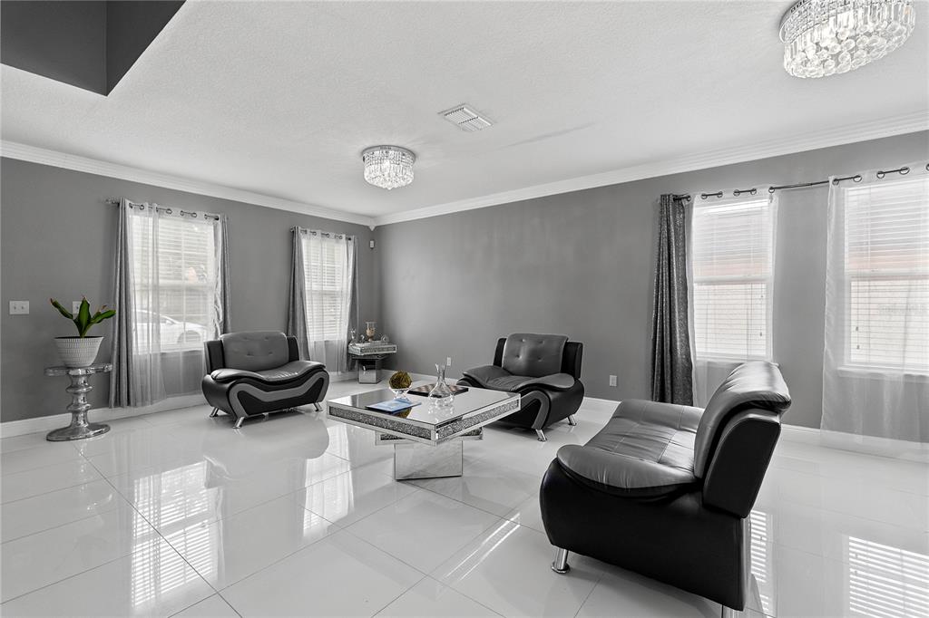 A living room features gray walls, white tile floors, black leather furniture, and crystal chandeliers — 963 SPRINGS LANDING DRIVE, DELTONA, FL
