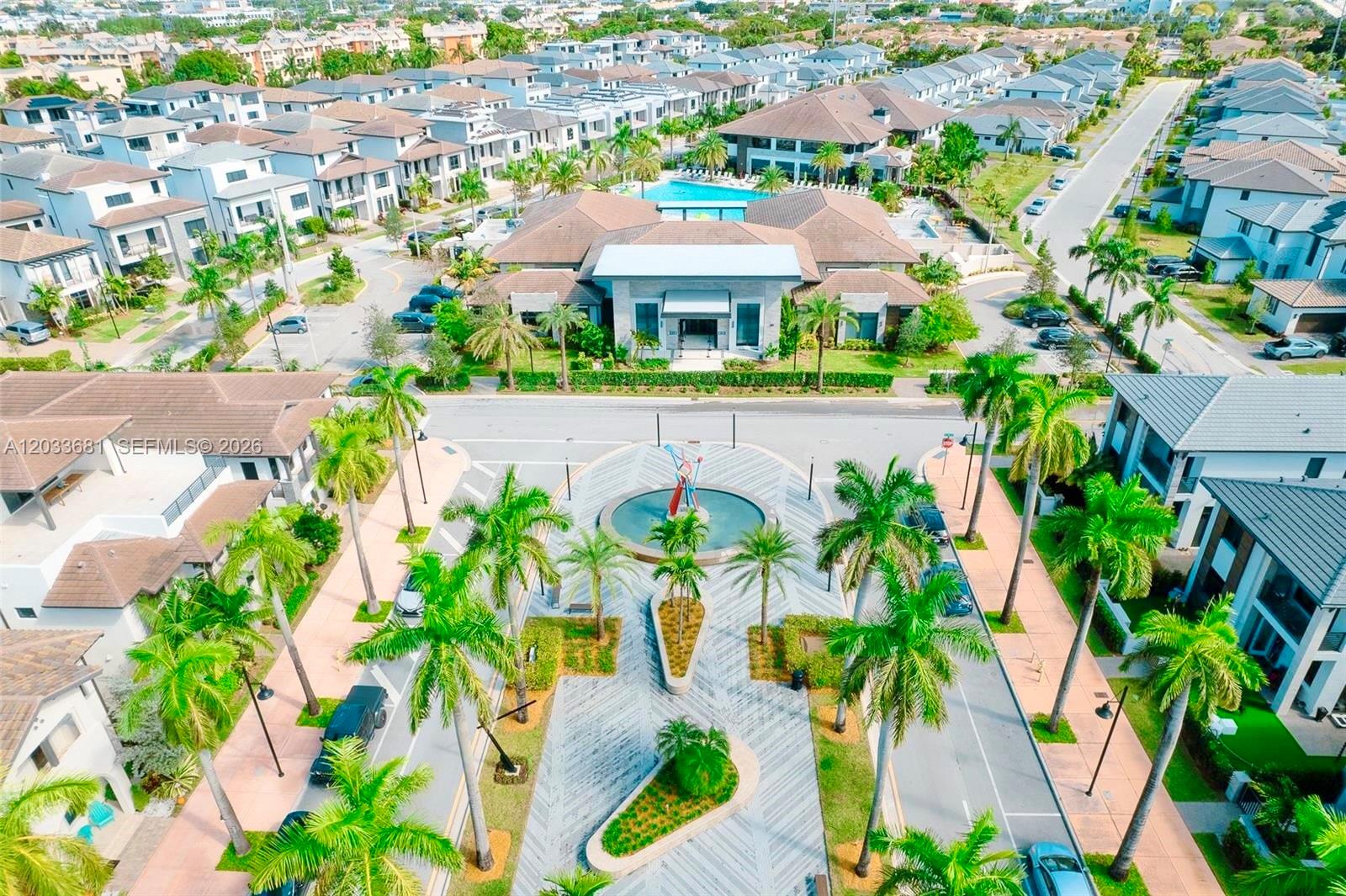 An aerial view shows a community clubhouse, swimming pool, and a landscaped fountain plaza — 4700 NW 84th Ave # 15, Doral FL 33166, DORAL, FL
