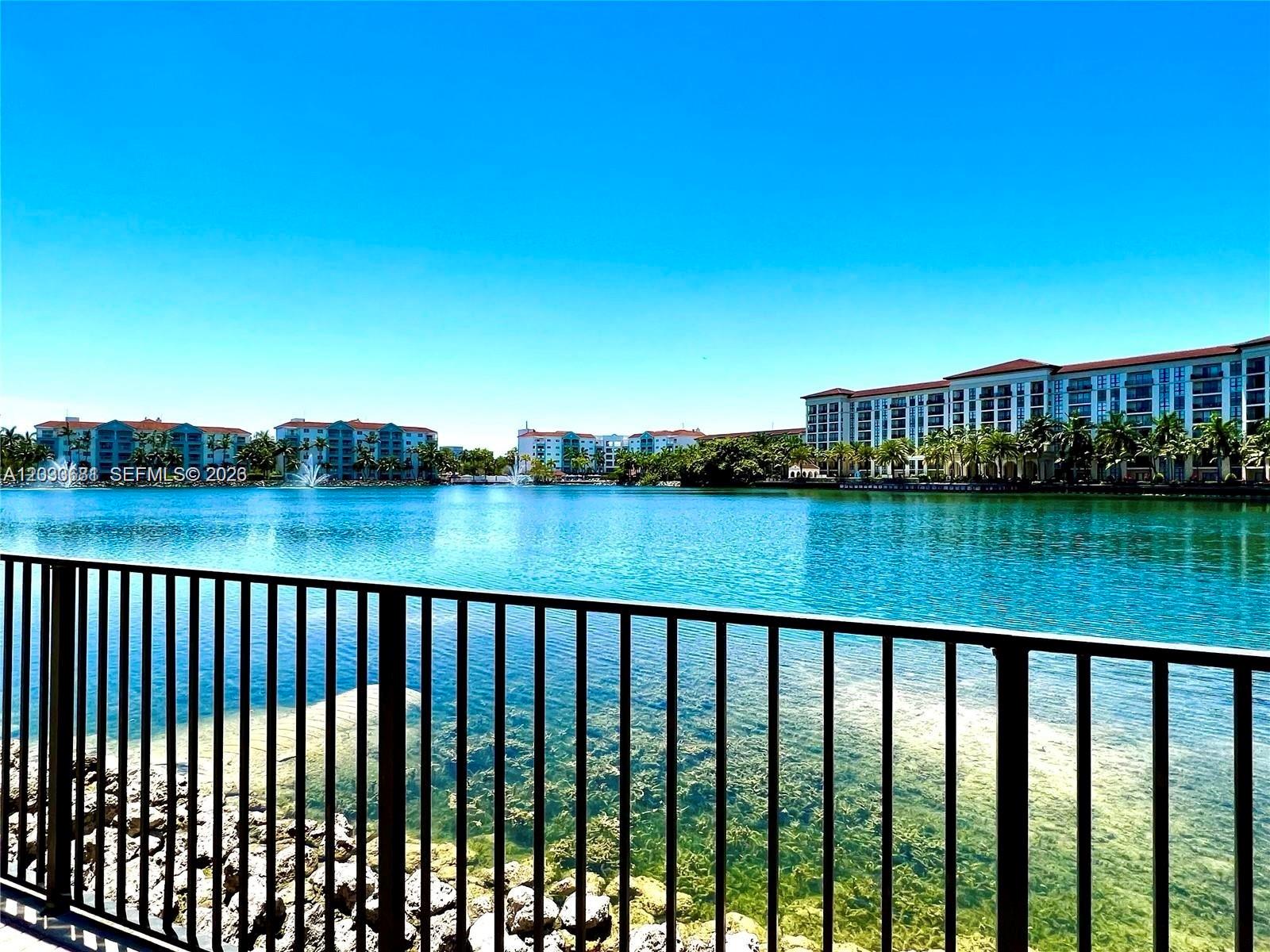 A view of a lake with apartment buildings in the background behind a metal fence — 4700 NW 84th Ave # 15, Doral FL 33166, DORAL, FL
