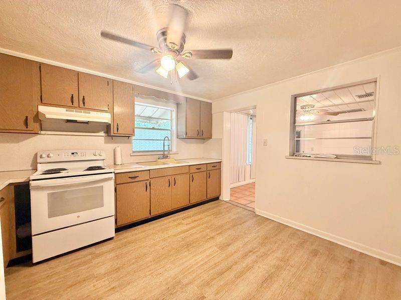 A kitchen features light wood cabinets, a white stove, and wood-look flooring — 123 PENNSYLVANIA AVENUE, WINTER GARDEN, FL