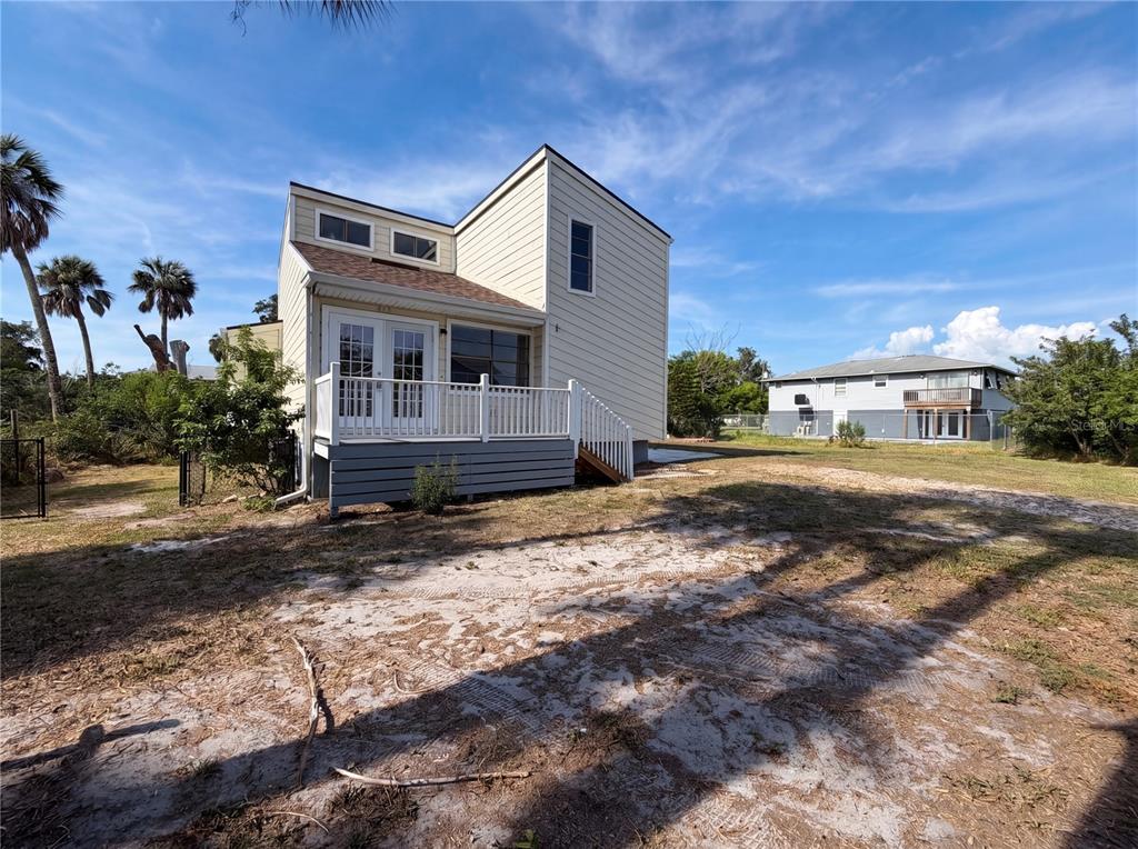 A two-story house with light-colored siding, a white deck, and a sandy yard — 516 42ND STREET COURT W, PALMETTO, FL