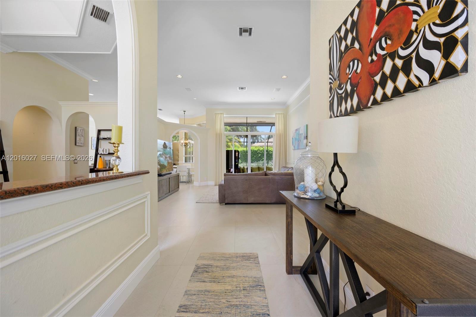A view from a hallway looking into a living room with tile floors and arches — 2538 Eagle Run Dr, Weston FL 33327, WESTON, FL