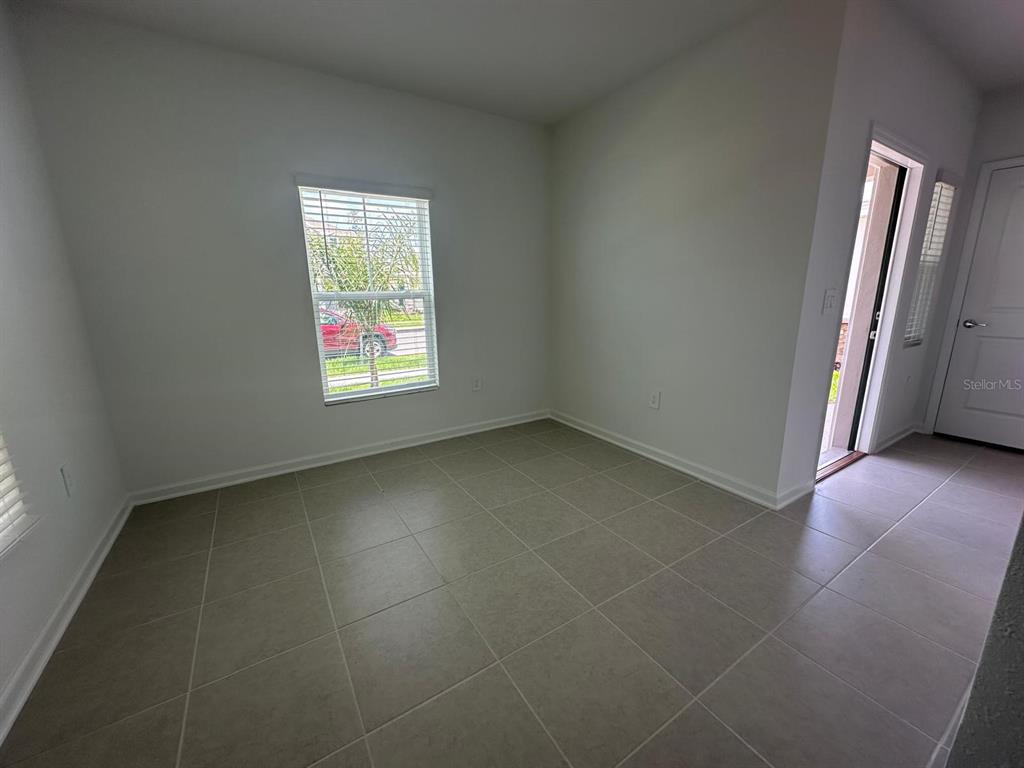 An empty room with light-colored tile flooring, white walls, and a single window — 2895 TRANSFORMATION WAY, CLERMONT, FL